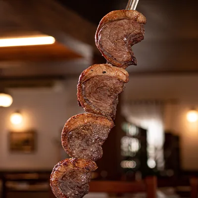 Carnes assadas no espeto, com capa de gordura dourada